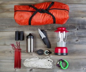 Camping Gear On Rustic Wooden Boards